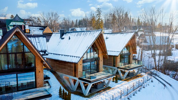A modern cabin with large windows, a balcony, and a snowy landscape. - Crystal Pine Luxury Villas Jacuzzi&Sauna (Zakopane)