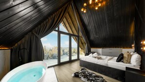 A modern bedroom with a large window, a bathtub, and a bed with a view of the outdoors. - Crystal Pine Luxury Villas Jacuzzi&Sauna (Zakopane)
