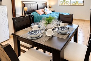 A dining table set with blue and white patterned bowls, white cups, and a potted plant. - Cabo Downtown Studios (Cabo San Lucas)