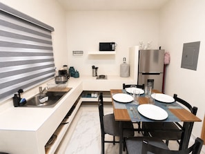 Cocina compacta con microondas, lavaplatos y refrigerador.