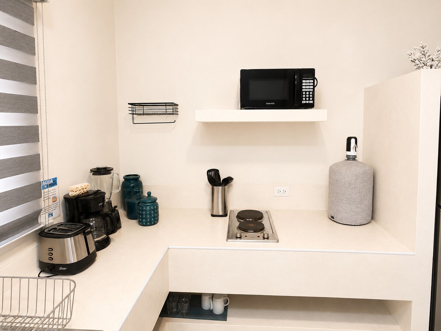 Una kitchenette equipada con microondas, tostadora, hervidor y estufa a gas.