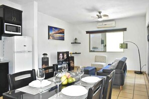 Un saló modern amb zona de menjador, cuina amb microones i una finestra gran.