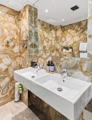 A bathroom with two sinks, a mirror, and marble walls. - Spacious and Luxury 4 bedroom Apartment in Central London (London)