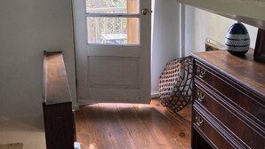 A room with a wooden door, a dresser, and a window. - The Boat Berth on Peaks Island (Portland)