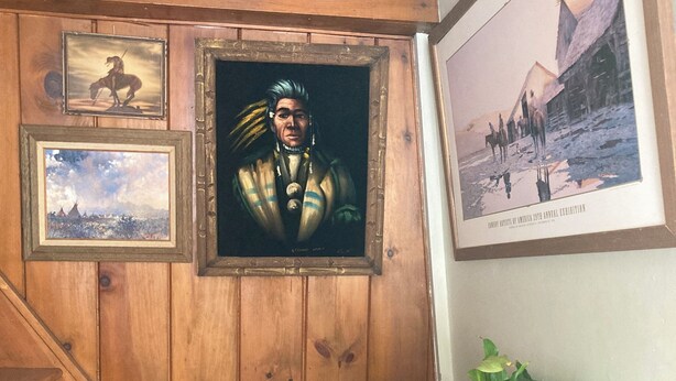 A wooden staircase leading to a door with framed artwork on the wall. - The Boat Berth on Peaks Island (Portland)