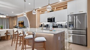 A modern kitchen with a central island, stainless steel appliances, and pendant lighting. - Star Wars Loft  Themed Bedrooms, Private Pool, Summer Kitchen & PS5 (Kissimmee)