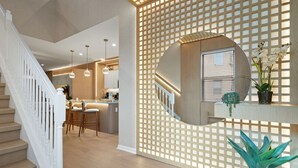 A modern interior with a staircase, a kitchen area, and a decorative wall with a circular mirror. - Star Wars Loft  Themed Bedrooms, Private Pool, Summer Kitchen & PS5 (Kissimmee)