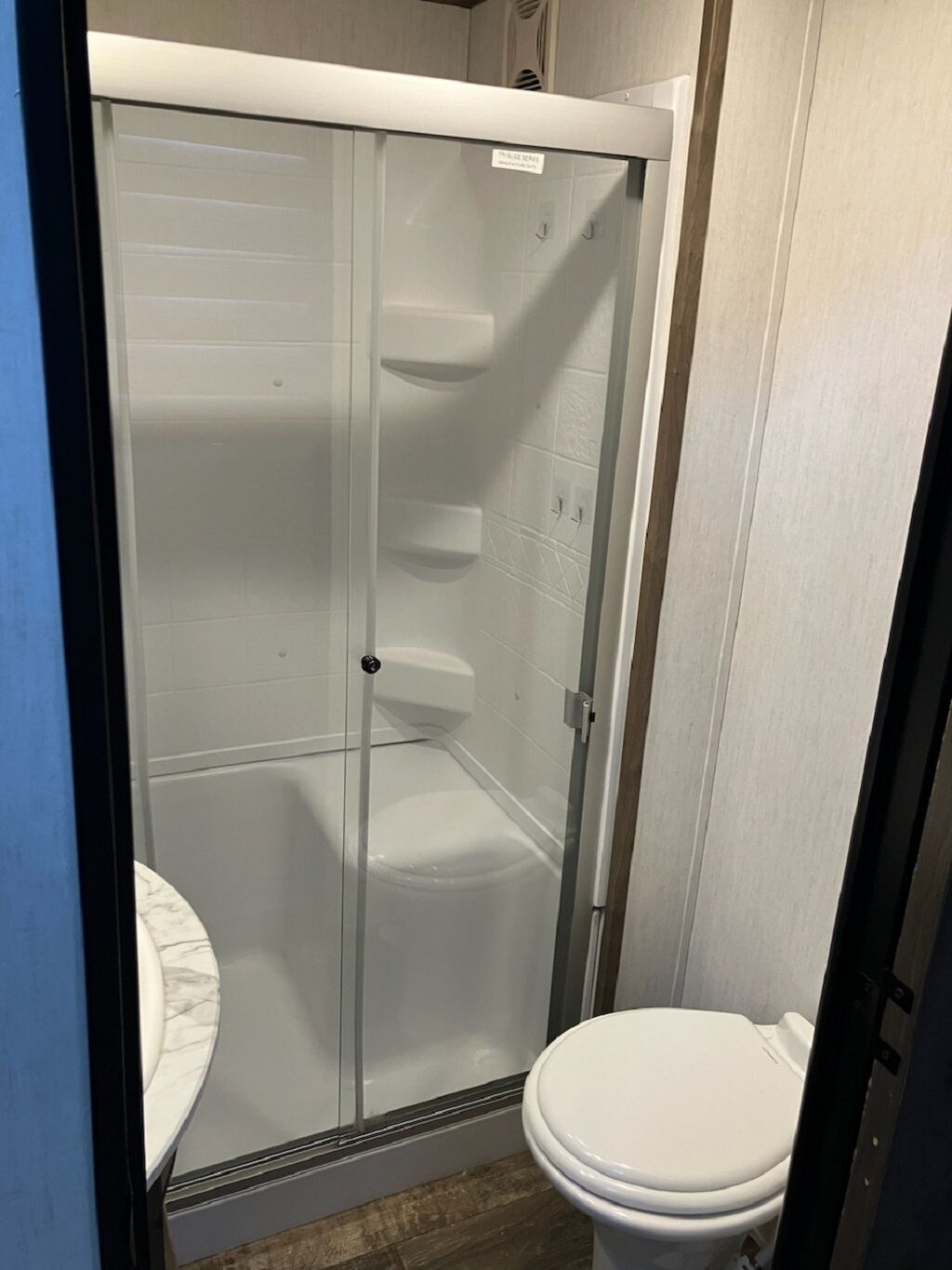 Kylpyhuoneessa on lasiseinällä varustettu suihku, wc ja marmorinen pesuallas.