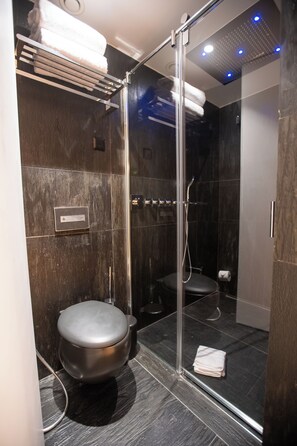 Ein modernes Badezimmer mit einer Duschkabine, einer Toilette und einem Handtuchhalter.