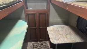 A bunk bed with a wooden headboard, a small stool, and a patterned mat on the floor. - Your Peaceful Waterfront Getaway Camping/Fishing Experience with Country Living (Pineview)