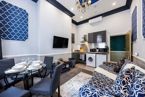 Ein modernes Wohnzimmer mit Essbereich, einer Küche und einem Waschraum.