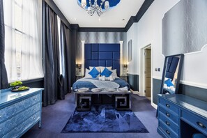 A bedroom with a large bed, a dresser, a mirror, and a chandelier. - Stunning Super king & Double Bed Apartment|Central London|Oxford St|Bond St (London)