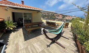 A patio with wooden benches, a hammock, and a dining table. - Pretty "Terrace and Sea" house ideally located (Cerbère)