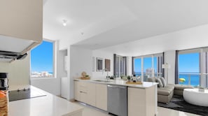 Eine moderne Wohnung mit Küche, Essbereich und Wohnzimmer, mit großen Fenstern und Blick auf die Stadt.