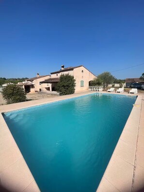 A rectangular swimming pool with a tiled edge, surrounded by a light-colored deck. - Villa Passarinho (Vidauban)