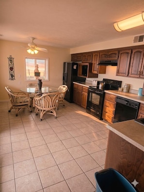 A kitchen with a dining table, chairs, a refrigerator, stove, oven, and cabinets. - Markley Manor - Beautiful views (Jasper Township)