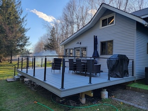 A house with a deck, outdoor furniture, and a grill.