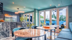 Una cocina moderna con salpicadero de mármol, un comedor con mesa y sillas redondas, y una zona de estar con sofá.