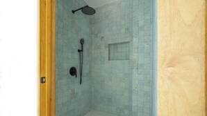 A small, enclosed shower area with tiled walls and a wooden door frame. - Luxury Beachfront Mansion (Provincia de Guanacaste)