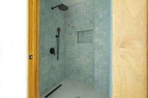 A small, enclosed shower area with tiled walls and a wooden door frame. - Luxury Beachfront Mansion (Provincia de Guanacaste)