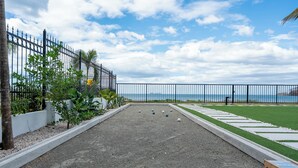 A croquet court with a view of the sea, surrounded by a fence and greenery. - Luxury Beachfront Mansion (Provincia de Guanacaste)