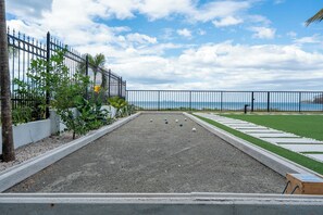 A croquet court with a view of the sea, surrounded by a fence and greenery. - Luxury Beachfront Mansion (Provincia de Guanacaste)