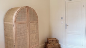 A room with a wooden wardrobe, a white door, and a woven rug on a wooden floor. - Stunning Villa in the Arcachon Basin with a Pool (Audenge)