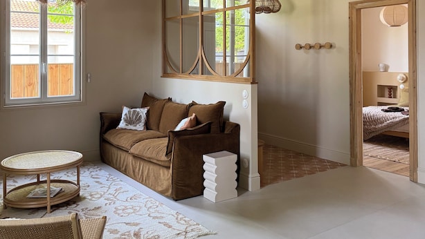 A room with exposed wooden beams, a sofa with cushions, a woven table, and a patterned rug. - Stunning Villa in the Arcachon Basin with a Pool (Audenge)