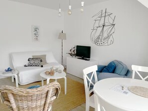 A modern living room with a white sofa, a dining table, and a TV on a stand. - T3 4/6p Side sea view Terrace 30m from the Beach (La Baule-Escoublac)