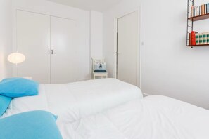 A bedroom with a bed, a chair, a bookshelf, and a wardrobe. - T3 4/6p Side sea view Terrace 30m from the Beach (La Baule-Escoublac)