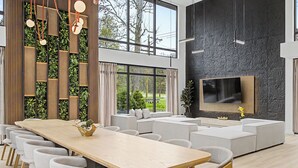Um interior moderno com uma mesa de jantar comprida, várias cadeiras, um sofá e uma televisão de tela plana presa a uma parede texturizada.
