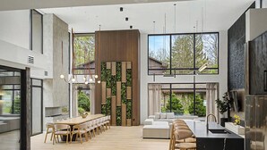 Uma cozinha moderna com uma ilha grande, banquetas de bar e vista para o exterior.