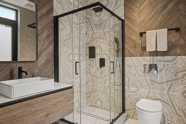 A bathroom with a shower, sink, and toilet.
