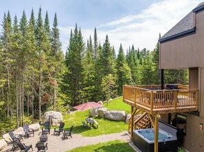Een chalet met terras, zitplaatsen buiten en een jacuzzi.
