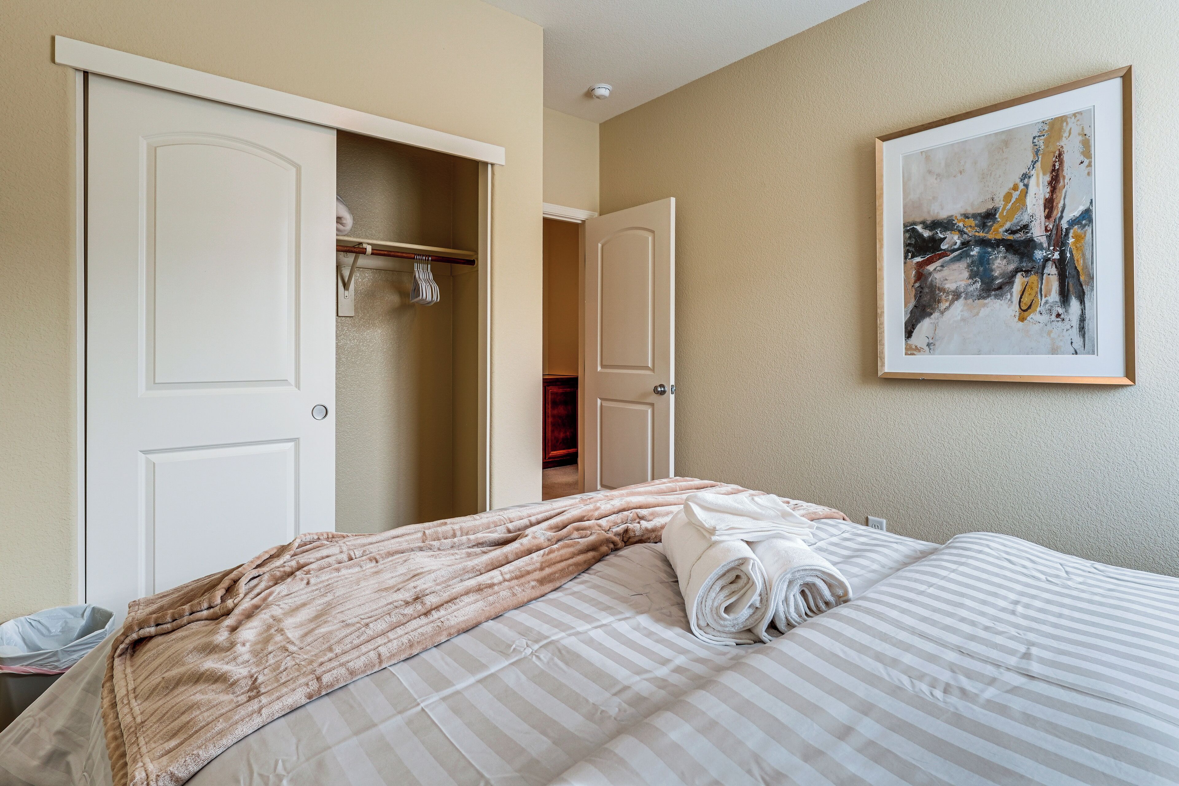 Ein Hotelzimmer mit Bett, Schrank und einem Bild an der Wand.