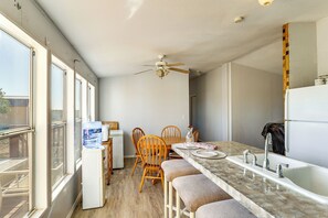 A compact kitchen with a dining area, a water dispenser, and a ceiling fan. - Hualapai Mountain Views & Deck! Yucca Getaway (Yucca)