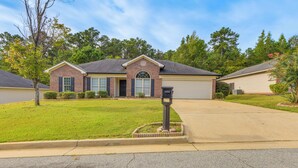 A residential house with a garage, a well-maintained lawn, and a mailbox. - 6 Mi to Fort Benning: Quiet Home w/ Patio & Yard (Columbus)