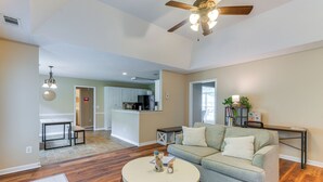 A spacious living room with hardwood flooring, a round coffee table, a grey sofa, and a ceiling fan. - 6 Mi to Fort Benning: Quiet Home w/ Patio & Yard (Columbus)