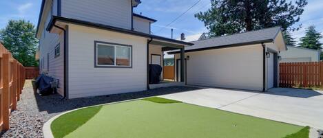 A two-story house with a garage, a covered patio, and a well-maintained lawn.