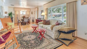 A spacious living room with a large window, a dining area, and a cozy seating arrangement. - Shop, Dine & Explore: Home 3 Mi to NRG Stadium (Houston)