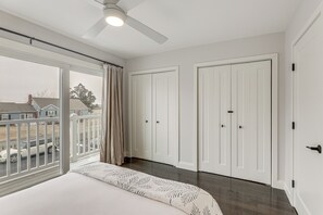 Ein Schlafzimmer mit einem großen Bett, einem Deckenventilator und Blick ins Freie.