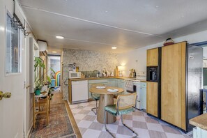 Une cuisine de taille réduite équipée d’un four à micro-ondes, d’un réfrigérateur et de meubles de rangement en bois.
