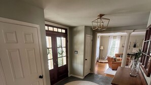 A spacious hallway with a round rug, wooden flooring, and a door leading to a living area with a sofa and a lamp. - 1.7 Miles from PGA Championship - tremendous outdoor space with back deck (Berwyn)