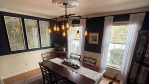 A dining room with a dark wooden table, six chairs, a decorative runner, and a hanging light fixture. - 1.7 Miles from PGA Championship - tremendous outdoor space with back deck (Berwyn)