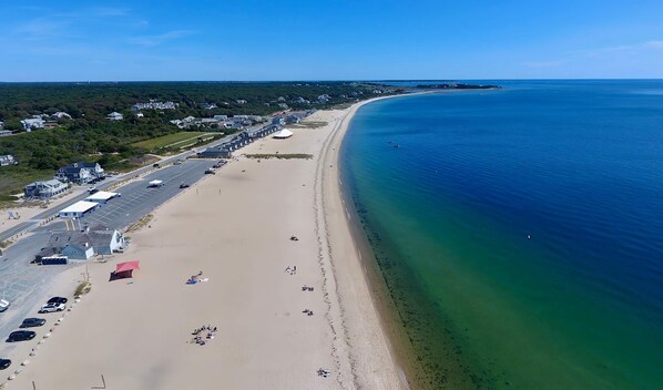 An aerial view of a beach with a parking lot, beachgoers, and a clear blue ocean. - Private Pool, Central AC, Dog Friendly! (Barnstable)