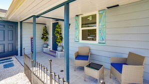 A covered porch with wicker furniture and potted plants. - Sarasota Home: Near Beaches & Downtown! (Sarasota)