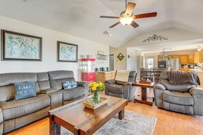 A living room with a gray sofa, a wooden coffee table, and a ceiling fan.