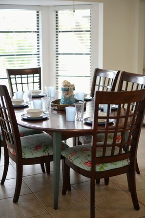 Een eettafel met stoelen, een vaas en glazen.