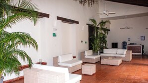 A spacious indoor area with multiple seating arrangements, including sofas and a small table, surrounded by potted plants. - Charming Studio with Balcony + Pool on Santo Domingo square, old city (Cartagena de Indias)