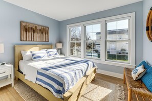 A bedroom with a bed, bedside tables, a window, and a view of the outside. - Family Friendly! Canal-Front Gem in Bethany Beach (Bethany Beach)